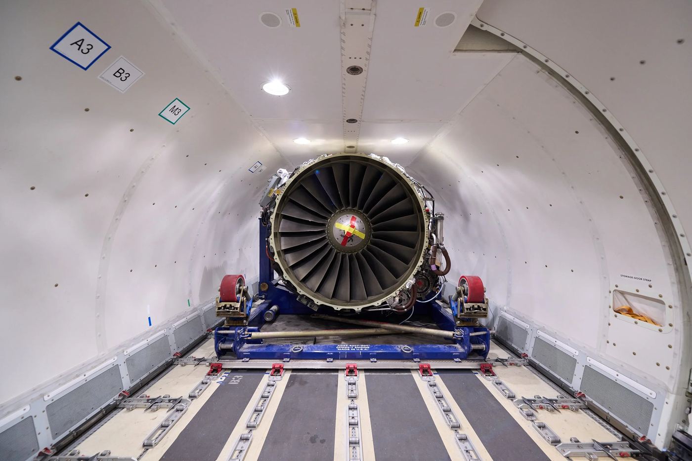 A jet engine on a transport stand inside a 737 freighter main deck.